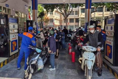 Penunggang motosikal beratur bagi mengisi minyak di stesen Hanoi. Foto Agensi