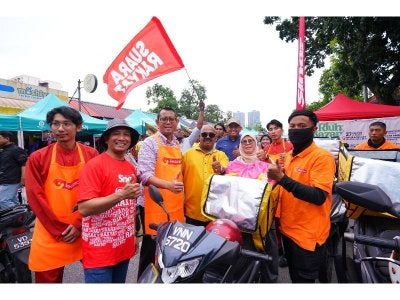 Penyelaras Dewan Undangan Negeri (DUN) Taman Medan, Halimey Abu Bakar (tiga dari kiri) dan Rosli (dua dari kanan) bersama rider yang akan mengagihkan makanan kepada penerima terpilih. 