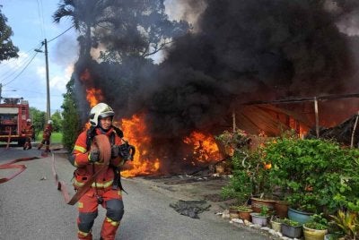 Anggota bomba dan penyelamat bertungkus-lumus memadamkan kebakaran dua rumah di Kampung Kepayang, Fair Park pada Selasa. Foto JBPM Perak 