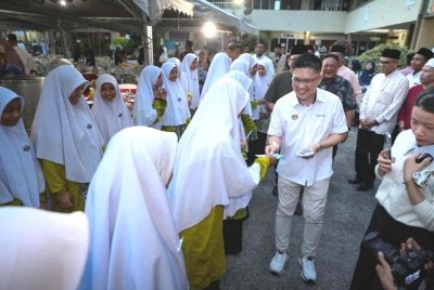 Kah Woh menyampaikan sumbangan duit raya kepada pelajar ketika hadir ke Program Jaulah Ramadan Kementerian Pendidikan di Sekolah Agama Bantuan Kerajaan Maahad Al Tarbiah Al Islamiah pada Selasa. Foto Bernama