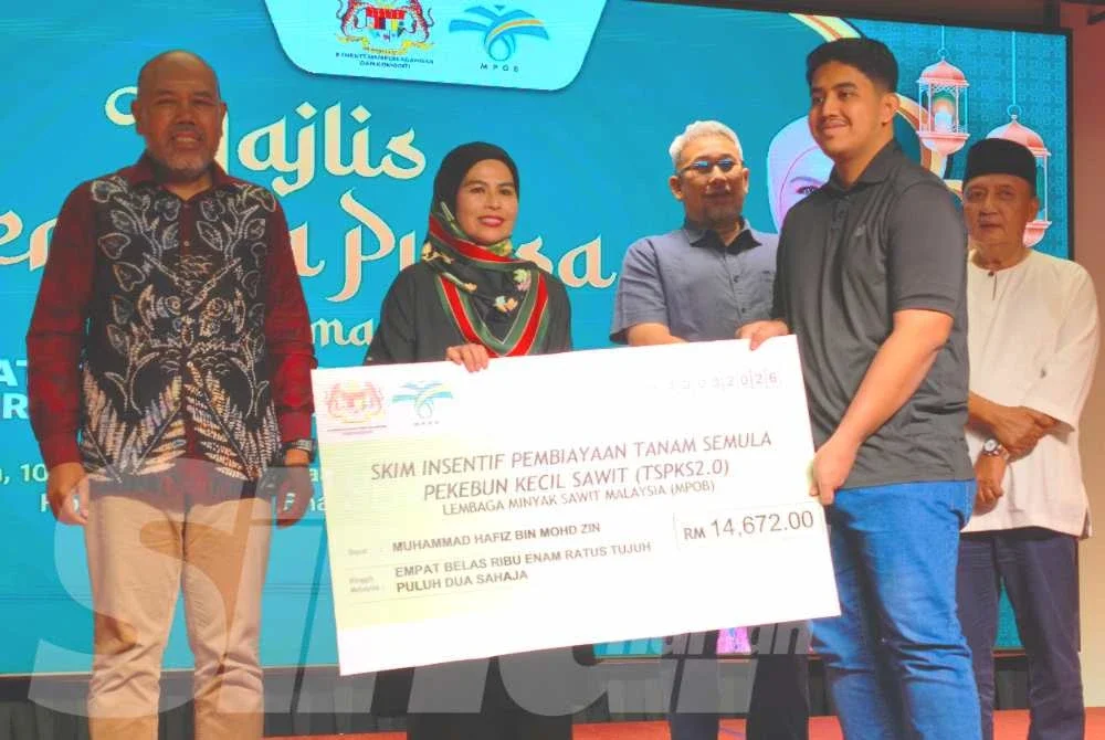 Noraini (dua dari kiri) menyampaikan Skim Insentif Pembiayaan Tanam Semula Pekebun Kecil Sawit kepada penerima pada Majlis Berbuka Puasa di Kota Bharu pada Selasa.