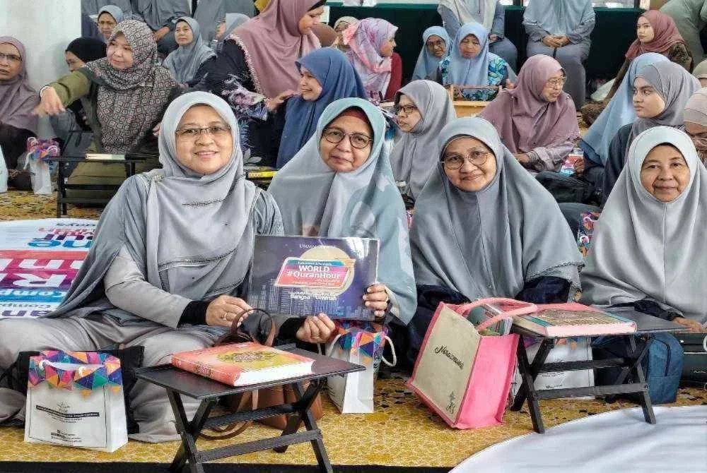 Peserta wanita yang hadir memeriahkan World #QuranHour peringkat negeri Pahang bergambar kenangan bersama plakad program di Masjid Sultan Ahmad Shah Sungai Isap, di sini pada Rabu.