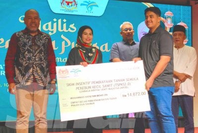 Noraini (dua dari kiri) menyampaikan Skim Insentif Pembiayaan Tanam Semula Pekebun Kecil Sawit kepada penerima pada Majlis Berbuka Puasa di Kota Bharu pada Selasa.