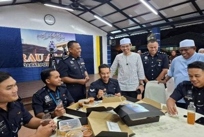 Muhammad Kamil (berdiri, tiga dari kanan) menyantuni anggota polis sempena Majlis Apresiasi Barisan Hadapan, Santuni Wira Madani dan Singgah Sahur bersama warga Ibu Pejabat Polis Kontinjen (IPK) Perak pada Rabu. 