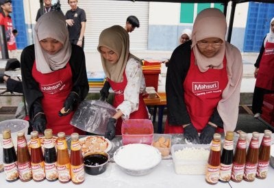 Tiga penuntut menyediakan piza menggunakan produk Mahsuri dalam penyediaan hidangan itu.
