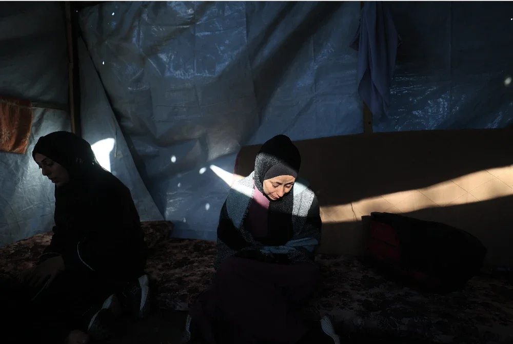 Wanita Palestin menunjukkan reaksi mereka sambil duduk di dalam khemah di sebuah kem susulan serangan Israel semalaman di Nuseirat, Jalur Gaza tengah. Foto AFP