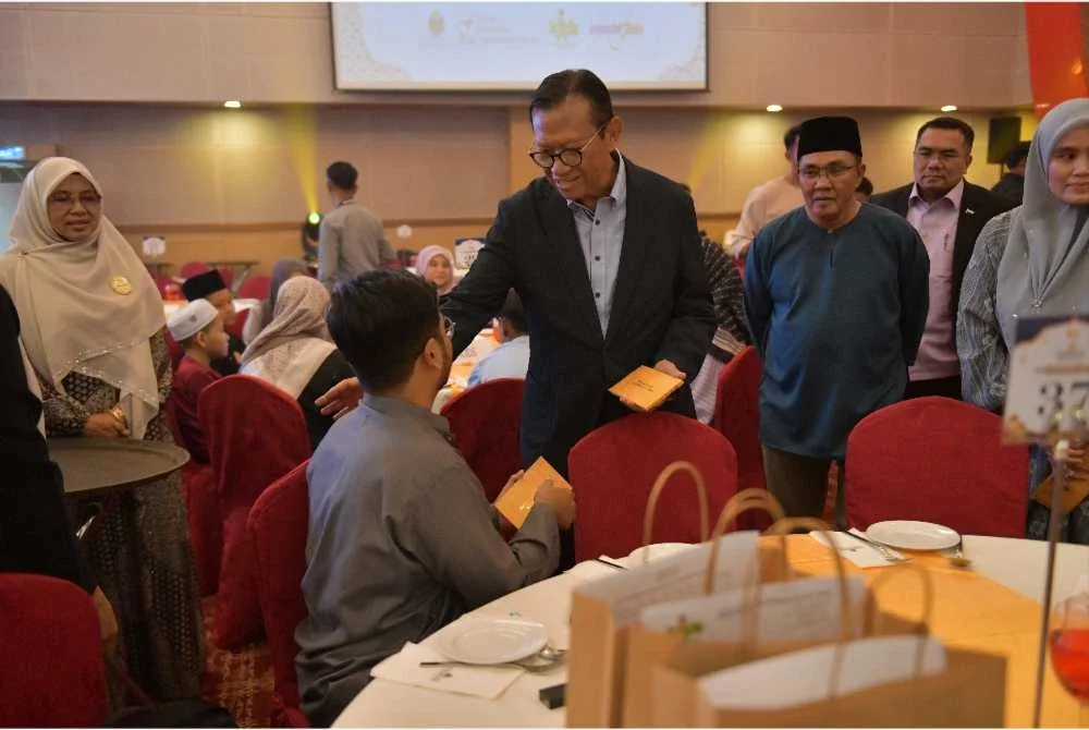 Pengerusi Felda, Datuk Seri Ahmad Shabery Cheek diiringi Ketua Peneroka Felda, Datuk Sulong Jamii Mohamed Shariff (kanan) menyerahkan sumbangan pada majlis bebuka puasa anjuran Waqaf Felda.
