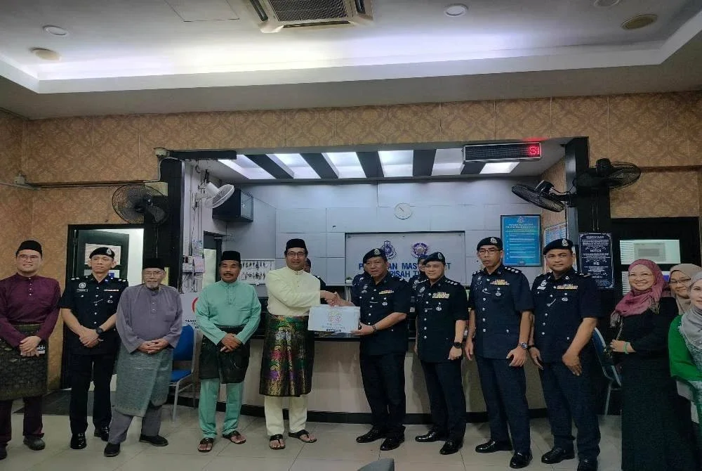 Mohd Azamanizam (lima dari kiri) menyerahkan pek makanan kepada Nor Akmal sempena Program Singgah Sahur Perdasama di Balai Sentral IPD Ipoh di sini pada Rabu.