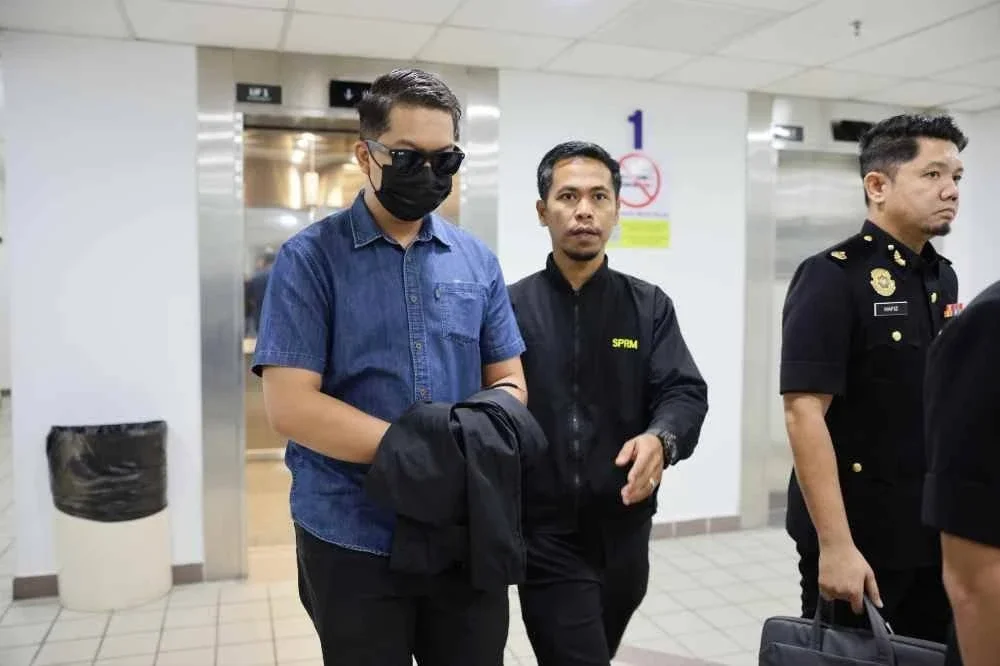 Mohamad Syazwan (kiri) dibawa keluar dari Mahkamah Sesyen Kuala Terengganu pada Khamis.