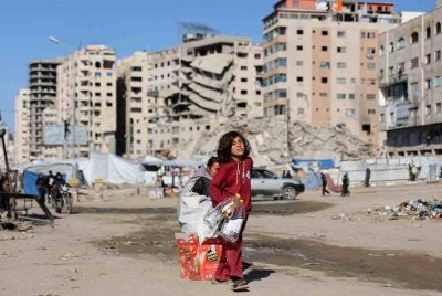Seorang gadis Palestin yang terpaksa berpindah sambil membawa barangan di Bandar Gaza. Foto AFP