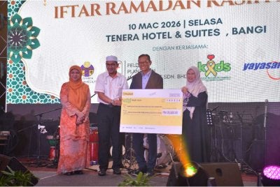 Ketua Pegawai Eksekutif Waqaf Felda, Hisyam Ahmad ( dua kiri) menyerahkan replika cek sumbangan kepada Pengerusi KIDS, Azniah Ghulam (kanan) disaksikan oleh Pengerusi Felda, Datuk Seri Ahmad Shabery Cheek pada Isnin.