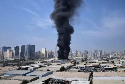 Kepulan asap hitam dari sebuah gudang di kawasan perindustrian Bandar Sharjah di UAE susulan laporan serangan Iran di Dubai. Foto Agensi