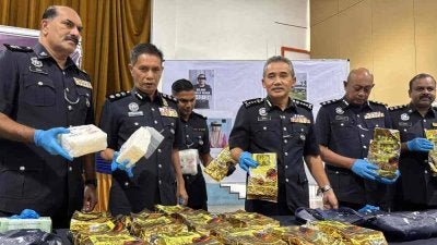 Adzli (tiga dari kanan) menunjukkan bungkusan dipercayai mengandungi dadah syabu yang dirampas dari sebuah inap desa di Kampung Permatang Rengan di Kota Kuala Muda pada Selasa. 