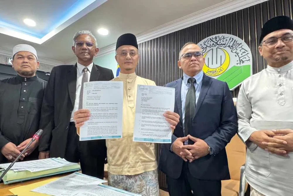 Mohamad (tengah) bersama Habib (dua dari kiri) menunjukkan surat tuntutan yang dikeluarkan kepada empat individu yang didakwa mengeluarkan kenyataan fitnah terhadapnya, MAINPP dan Zakat MAINPP.