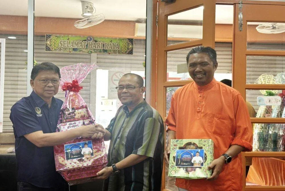 Asmuni (kiri) menyampaikan hamper Aidilfitri kepada Ketua Biro Astro Awani Perak, Abd Razak Ali di Wisma Amanah Negeri Perak di sini pada Jumaat.