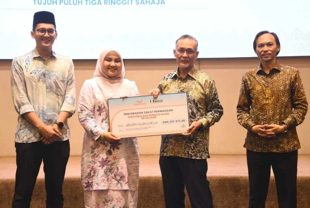 Zulkifli (dua, kanan) bersama Ahmad Azrin (kanan) menerima sumbangan zakat daripada Kedai Emas san Permata Nazeri Sri Gelugur sempena Majlis Penyerahan Zakat Korporat Tahun 2026 di Kuala Terengganu pada Khamis.