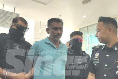 Ganesalingam (dua dari kiri) dibawa ke Mahkamah Majistret Klang pada Jumaat bagi menghadapi satu pertuduhan membunuh, minggu lalu.