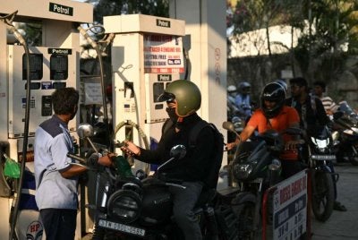 Orang ramai beratur untuk mengisi minyak kenderaan di sebuah stesen petrol di Chennai pada 12 Mac 2026, susulan kenaikan harga minyak akibat perang di Asia Barat. Foto: AFP