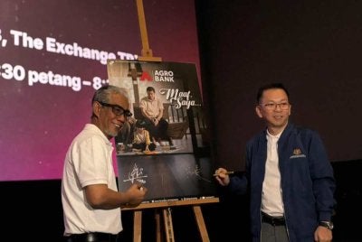Tengku Ahmad Badli Shah (kiri) bersama Foong Hin (kanan) menandatangani poster kempen pembukaan akaun tanpa deposit untuk 300 kanak-kanak autisme sempena pelancaran video raya Agrobank ‘Maaf Saya …’ di Aurum Theatre, Tun Razak Exchange, Kuala Lumpur.