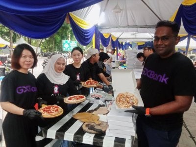 Dari kiri Christina, Nor Amira dan Kan Penny ketika menyiapkan juadah berbuka puasa semasa Iftar Rewang Pelajar anjuran GXBank di Universiti Malaya.