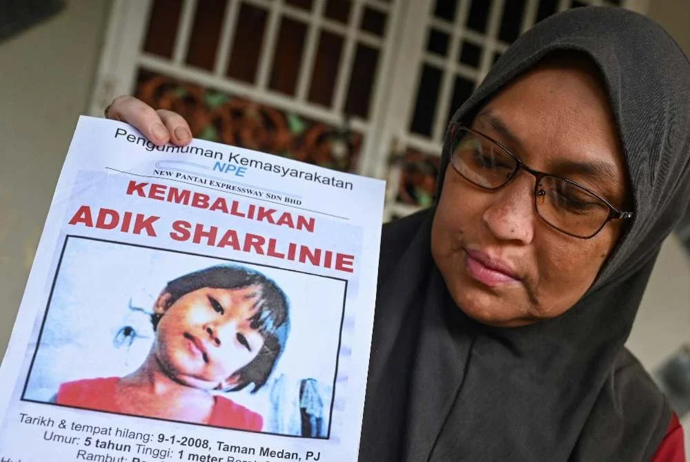 Suraya menatap gambar anaknya, Sharlinie yang hilang hampir dua dekad ketika berusia empat tahun. Foto: Bernama