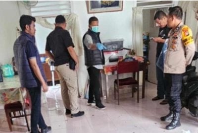Beberapa petugas forensik melakukan siasatan di rumah mangsa. - Foto Agensi