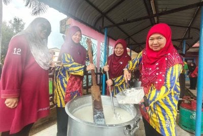 Kakitangan sekolah bergotong-royong menyediakan bubur lambuk untuk diagihkan kepada warga sekolah. 