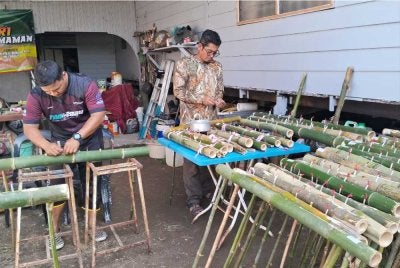 Ahmad Farid Shaifuddin (kanan) dan Muhammad Amirul (kiri) menyiapkan pelita buluh yang ditempah pelanggannya di Kampung Gong Limau, Chukai di Kemaman.