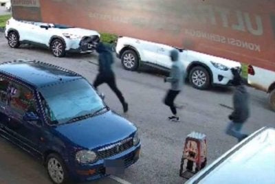 Rakaman CCTV menunjukkan dua daripada tiga suspek menggunakan parang mengejar mangsa. - Foto tular