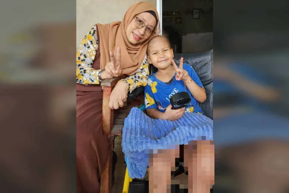 Zuraini (kiri) menyantuni seorang pesakit kanser kanak-kanak.