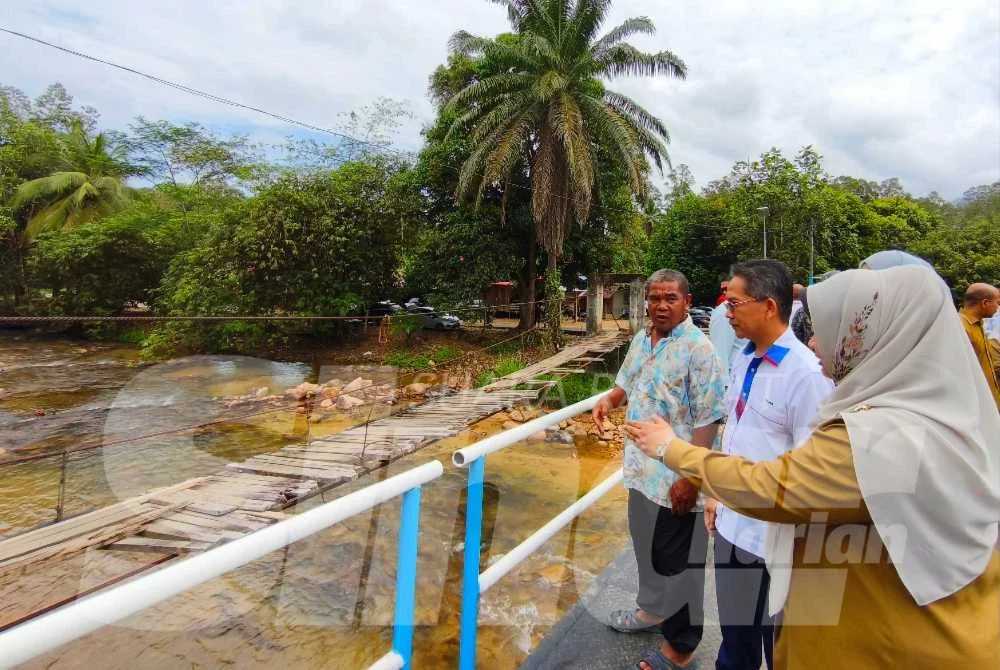 Wan Syukri (kiri) begitu gembira dan teruja berada di atas jambatan keluli berukuran 36 meter panjang dan tiga meter lebar itu yang mampu menampung kenderaan berat sehingga lima tan dengan anggaran kos RM200,000.
Foto:SINAR HARIAN/HAZELEN LIANA KAMARUDIN