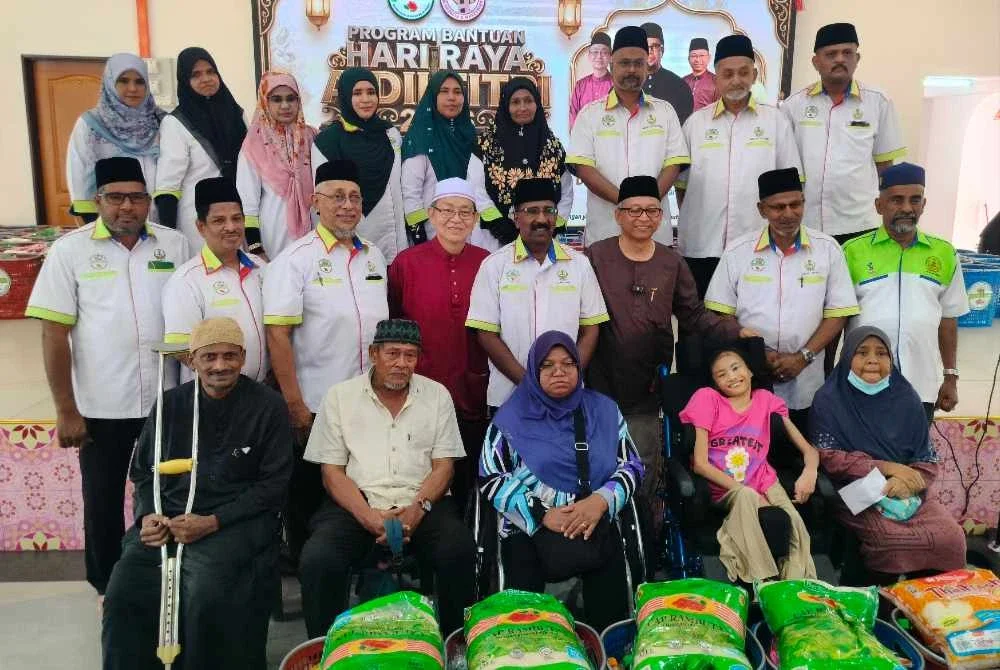 Mohamed Adib (barisan tengah, empat dari kanan) dan Azizul Kama (barisan tengah, tiga dari kanan) bersama penerima serta tetamu jemputan sempena Program Bantuan Hari Raya Aidilfitri PRIM di Dewan Masjid Muhammadiah (Masjid Cina Muslim) Tasek pada Ahad.