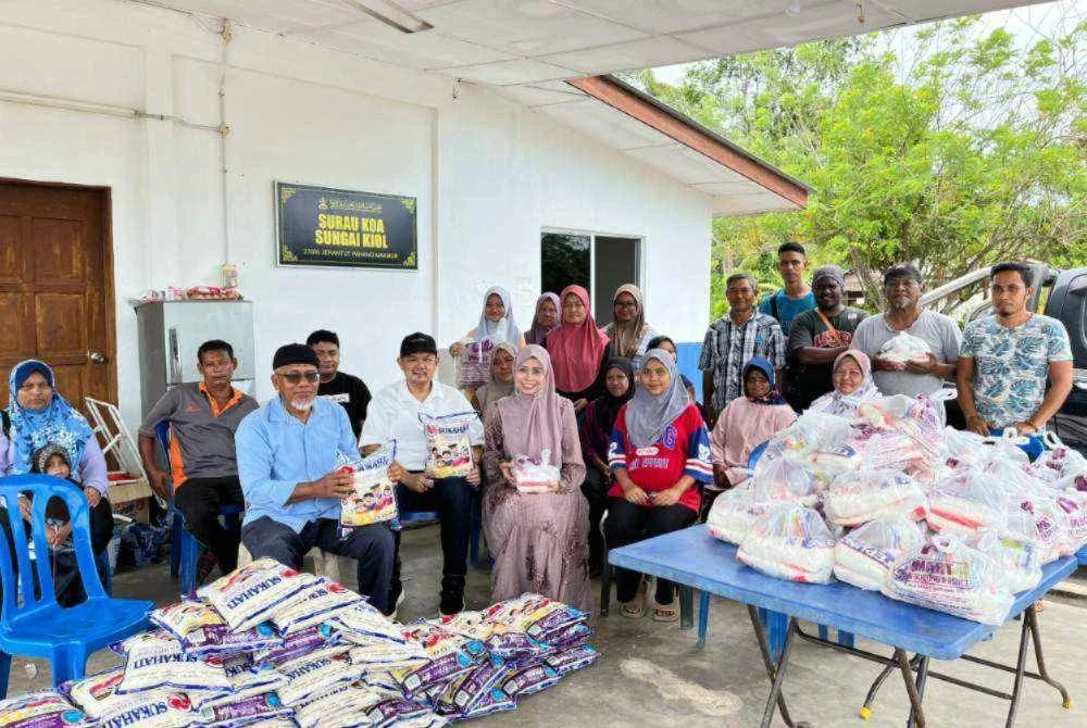 Ahmad Nazlan (hadapan kiri) bersama Dr Sharen dan Dr Noraini bergambar bersama penerima sumbangan dalam program Kongsi Rezeki melibatkan 61 keluarga Orang Asli mualaf di Kampung Sungai Kiol.