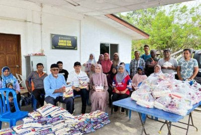 Ahmad Nazlan (hadapan kiri) bersama Dr Sharen dan Dr Noraini bergambar bersama penerima sumbangan dalam program Kongsi Rezeki melibatkan 61 keluarga Orang Asli mualaf di Kampung Sungai Kiol.