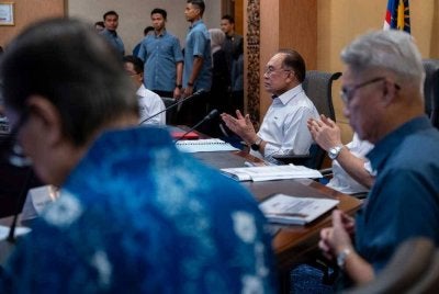 Perdana Menteri Datuk Seri Anwar Ibrahim mengaminkan bacaan doa sebelum mempengerusikan Mesyuarat Pembangunan Daerah Kota Kinabalu di Menara Kinabalu, hari ini. Foto Bernama.