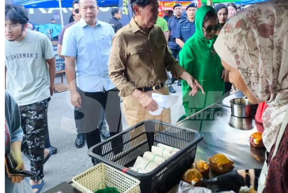 Ramli (dua dari kiri) bersama isteri turut membeli juadah berbuka puasa di Bazar Ramadan Jalan Mahkamah di Bayan Lepas.
