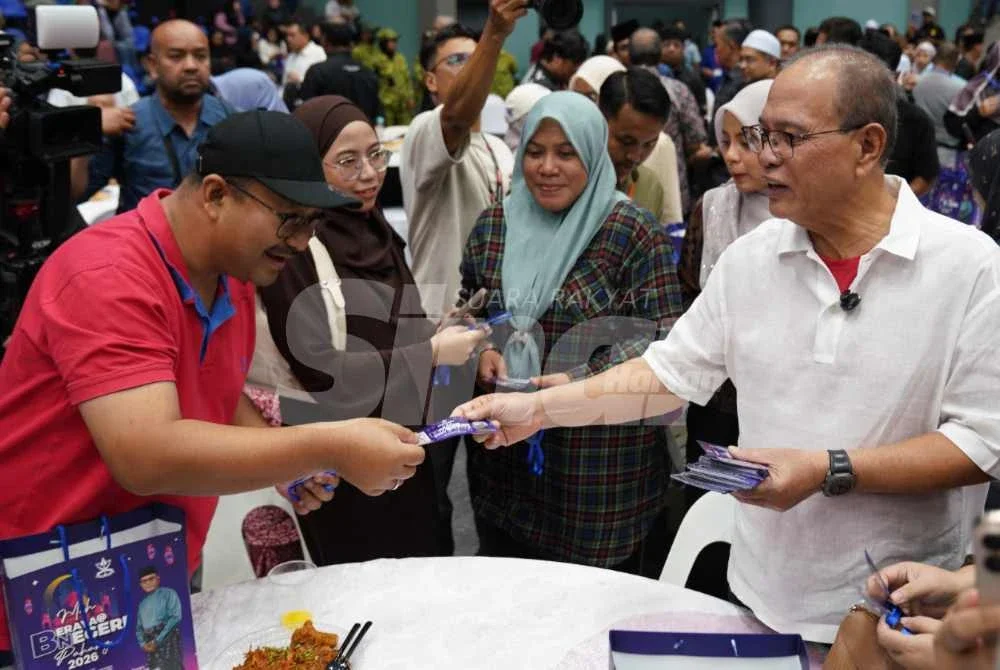 Wan Rosdy (kanan) menyerahkan baucar raya Moh Balik Negeri Pahang kepada anak-anak Pahang. Foto Sinar Harian/Rosli Talib