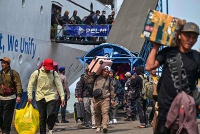 Sebuah feri membawa penumpang yang pulang ke kampung tiba di pelabuhan Perak di Surabaya pada Ahad.
