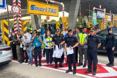 Shazeli (tengah) bersama Azrin (tiga dari kanan) ketika Kempen dan Advokasi Keselamatan Jalan Raya Sempena Hari Raya Aidilfitri di Plaza Tol PJS 2, Petaling Jaya pada Isnin.