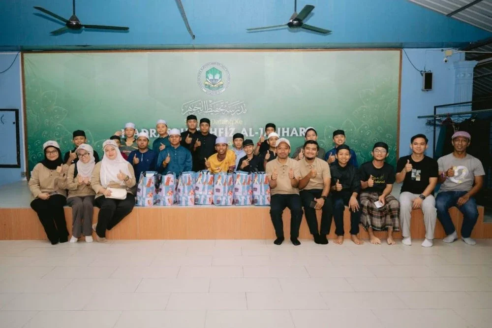 Sukarelawan bergambar dengan asnaf yang menerima sumbangan