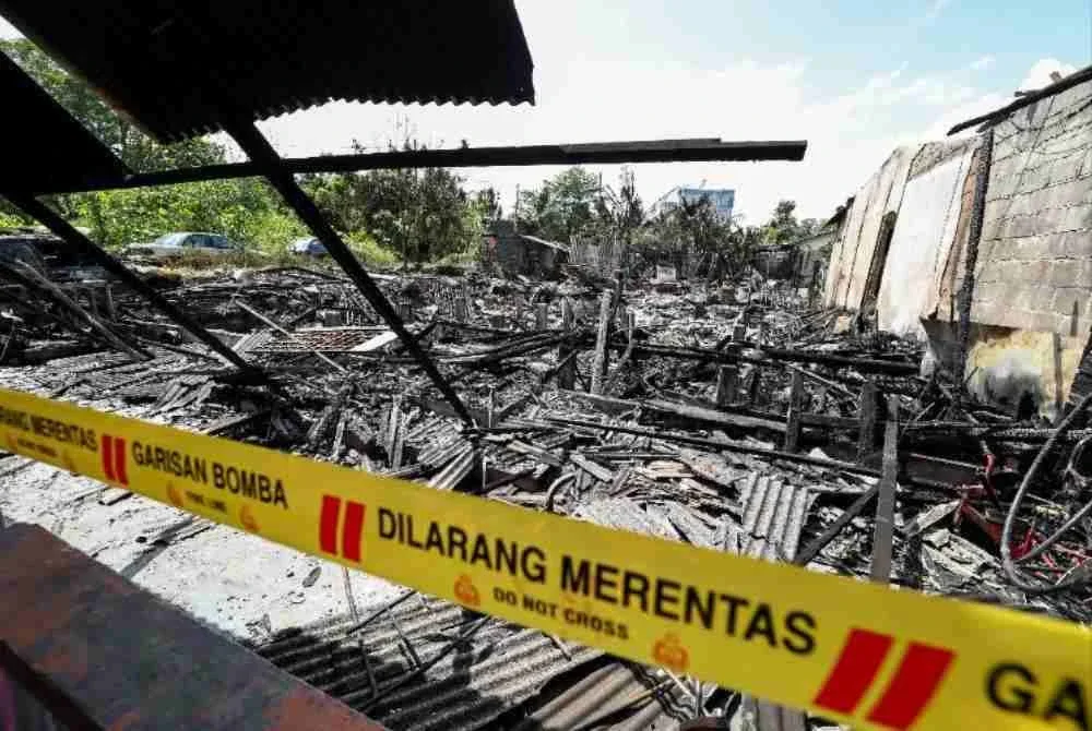 Keadaan dua daripada tiga rumah milik, Siti Robaizura bersama kakaknya, Siti Rozana di Kampung Plentong Baru, Masai, yang hangus dalam kebakaran mengejut pagi Selasa. Foto Bernama