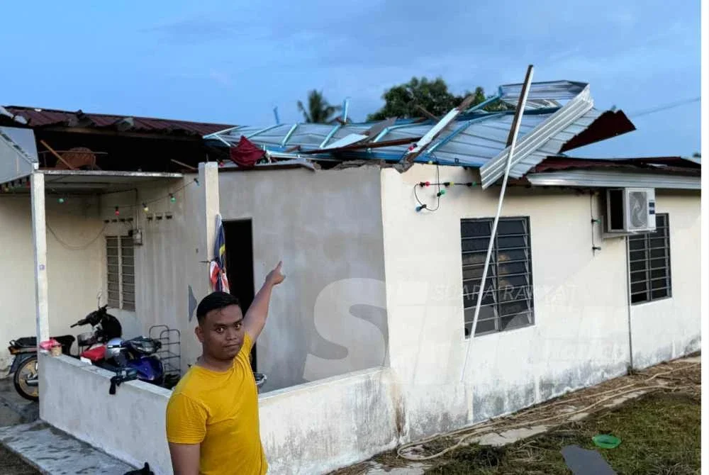 Mohd Asri menunjukkan keadaan bumbung rumahnya tercabut dilanda ribut.