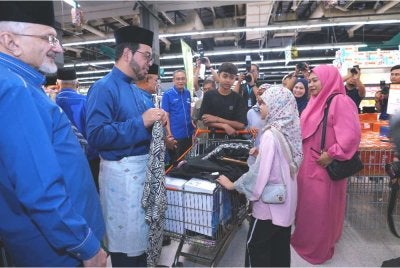 Zulkifli (dua dari kiri) berbual dan menyantuni penerima bantuan.