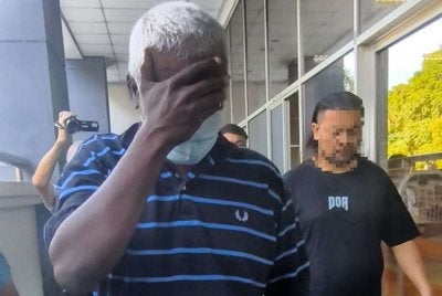 Mahendra (kiri) tiba di Mahkamah Majistret bagi pertuduhan di bawah Seksyen 505(b) Kanun Keseksaan berkaitan hantarannya di Facebook.