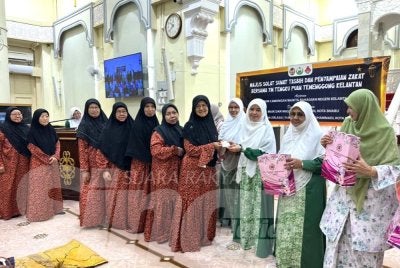 Wan Nor Hanita (tiga dari kanan) menyampaikan zakat kepada mualaf dari Tumpat.
