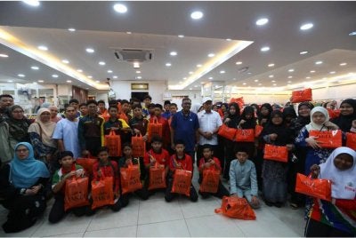 Zuraidi (tengah) bersama 56 anak yatim dan asnaf dari beberapa sekolah di Padang Terap datang membeli kelengkapan hari raya di Alor Setar.