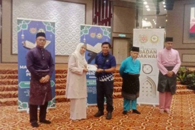 Zabidah (dua kiri) menyampaikan wakalah kepada penerima pada majlis tersebut.