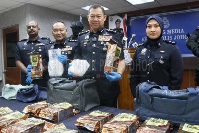Ab Rahaman (dua kanan) menunjukkan dadah yang dirampas. Foto Polis Johor