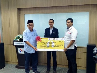 Mohammed Akhiar (kiri) menyerahkan cek cura Akaun Deposit Koperasi (ADK) Kumpulan Wang Rizab Statutori koperasi kepada wakil Co-opbank Pertama Cawangan Ipoh berjumlah RM662,214.54 sambil disaksikan oleh Mohd Firdaus Hussin (tengah).