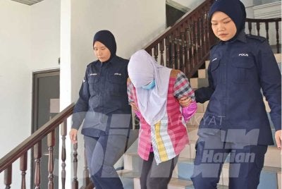 Tertuduh dibawa keluar dari Mahkamah Sesyen Ayer Keroh selepas prosiding mahkamah selesai